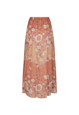 a-long-pleated-maxi-skirt-in-a-warm-peach-orange-color-featuring-a-large-scale-floral-pattern-in-cream-pink-and-light-purple-shown-against-a-plain-white-background