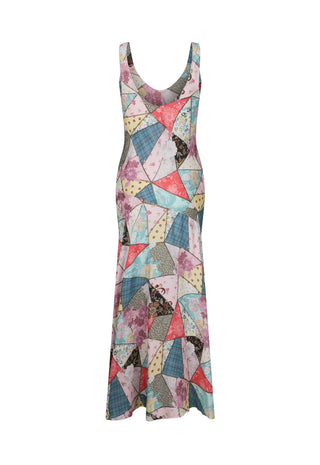 a-sleeveless-scoop-neck-maxi-dress-featuring-a-colorful-geometric-patchwork-print-with-triangles-and-irregular-shapes-in-pink-blue-yellow-and-gray-shown-against-a-plain-white-background