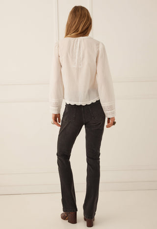  standing against a white paneled wall.