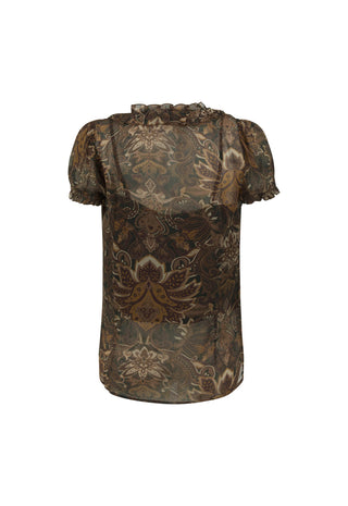  wearing a sheer brown lace short-sleeve top and beige wide-leg patterned pants. Large arched windows