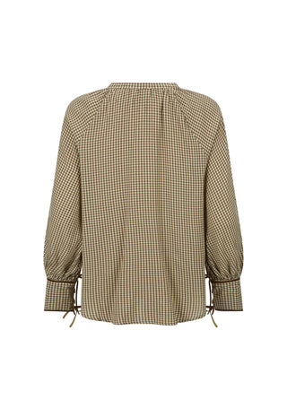  wearing a sheer patterned brown and beige blouse with a matching long skirt