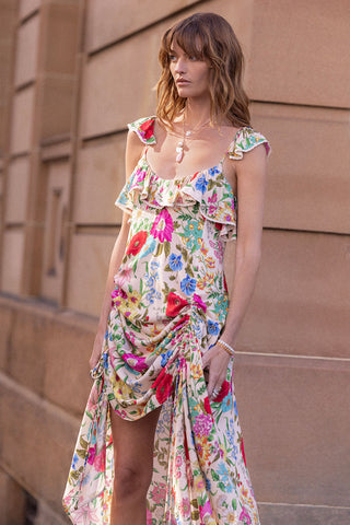 woman-wearing-a-colorful-floral-dress-against-a-beige-wall