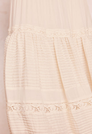 close-up-of-a-cream-colored-sheer-tulle-dress-with-horizontal-pleated-detailing-and-delicate-lace-trim