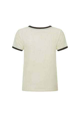 A woman wearing a cream ringer T-shirt with black trim and a vintage horse graphic on the front