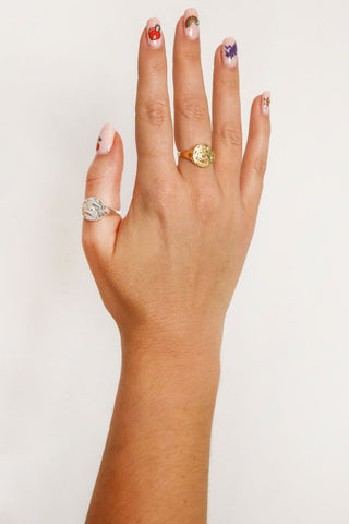 close-up-image-of-a-hand-with-painted-nails-wearing-rings-including-that-of-the-spell-s-silver-stargazer-zodiac-ring