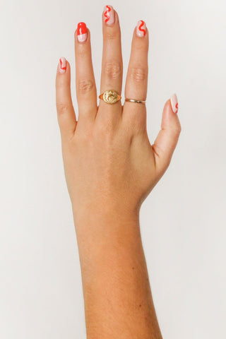 close-up-image-of-a-hand-with-painted-nails-wearing-gold-rings-including-that-of-the-spell-s-stargazer-zodiac-ring