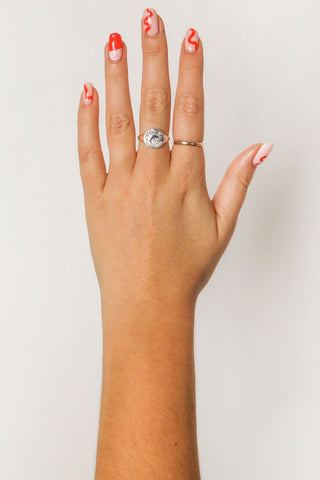 close-up-image-of-a-hand-with-painted-nails-wearing-rings-including-that-of-the-spell-s-silver-stargazer-zodiac-ring