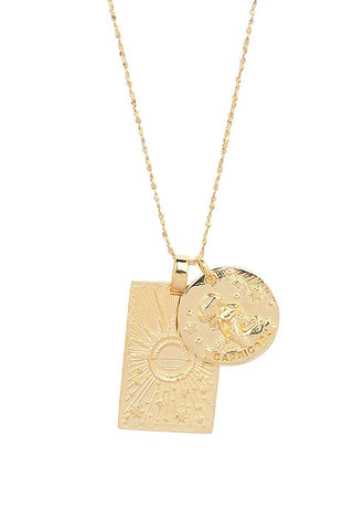 close-up-front-view-of-spell-s-capricorn-stargazer-zodiac-necklace-charms-one-charm-is-of-a-rectangular-shape-and-features-a-sun-with-stars-while-the-other-charm-is-circular-and-features-the-zodiac-label-and-icon