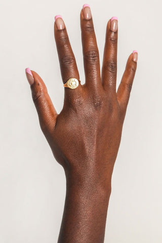 close-up-image-of-a-hand-with-painted-nails-wearing-gold-rings-including-that-of-the-spell-s-stargazer-zodiac-ring